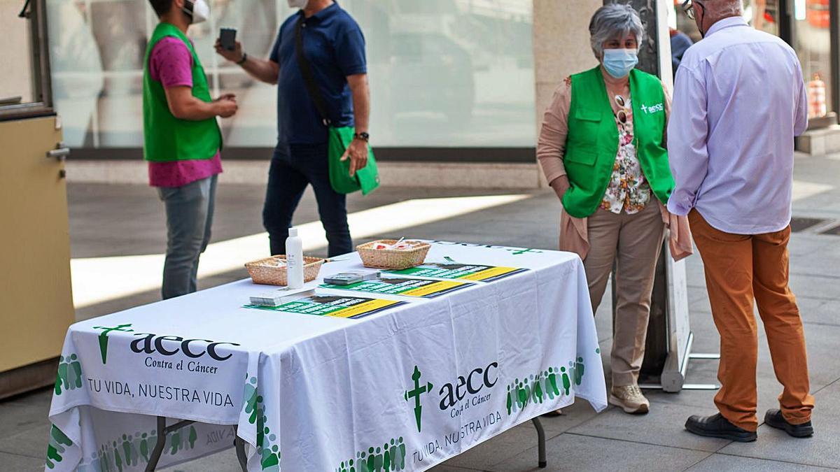 Voluntarios en la mesa informativa ubicada en la caseta de Santa Clara.