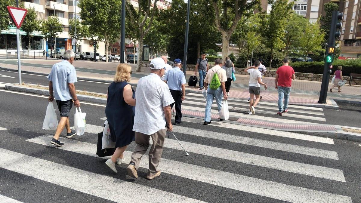 Una pareja de invidentes cruza un semáforo de Cardenal Cisneros.