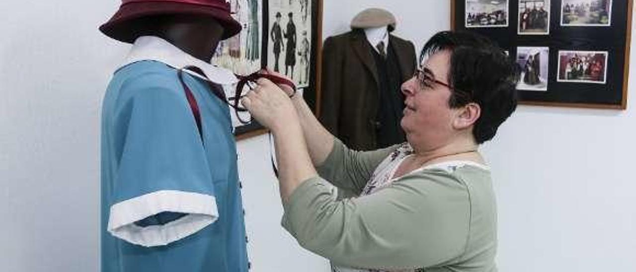 La profesora Isabel Lorenzo, que aparece en la foto de la izquierda retocando el lazo de un vestido.