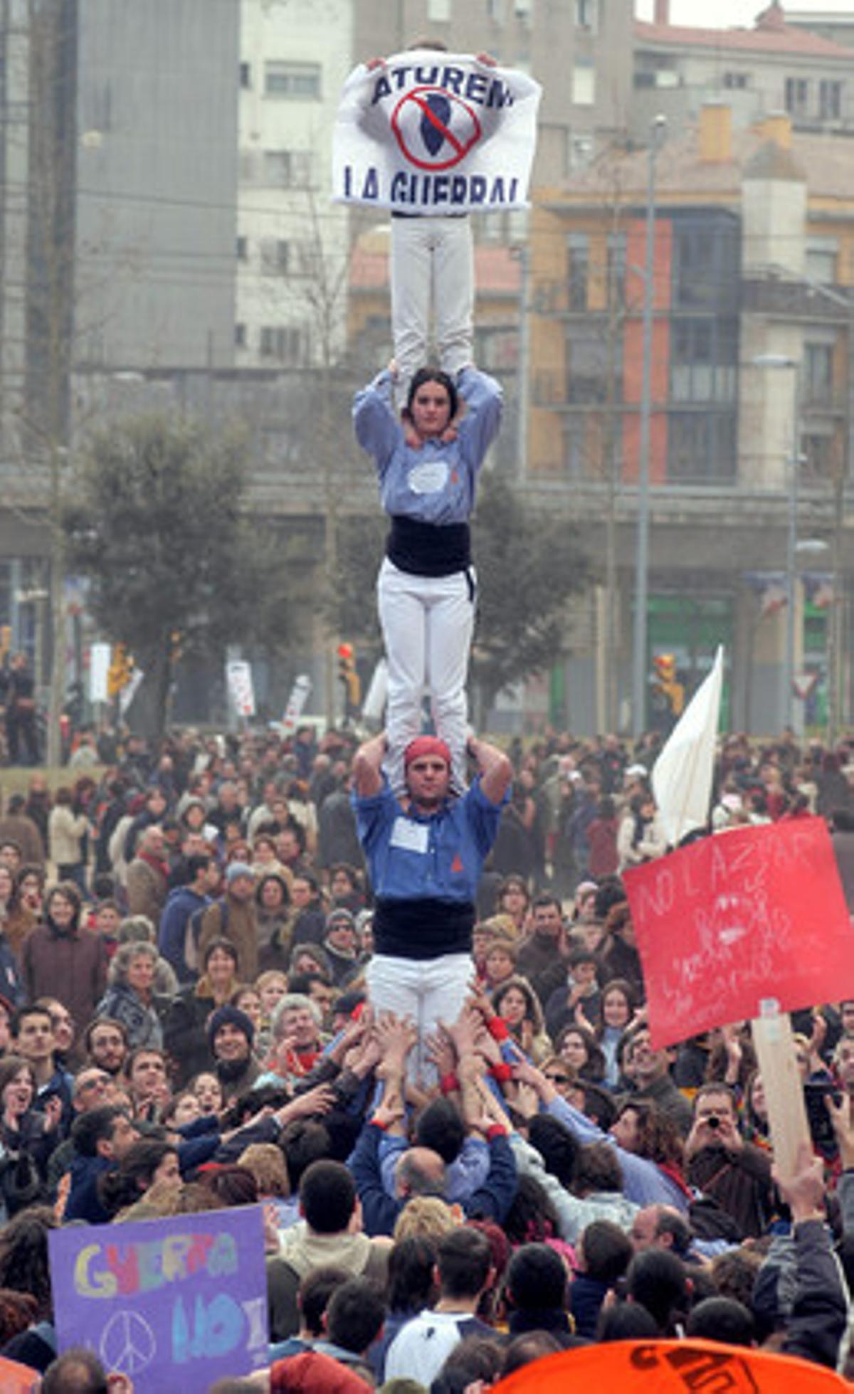 La afluencia de manifestantes batió récords en toda Catalunya. En la foto, unos ’castellers’ levantan una pancarta en Girona con el lema ’Aturem la guerra’. Cerca de 30.000 personas marcharon por las calles de la ciudad a favor de la paz.