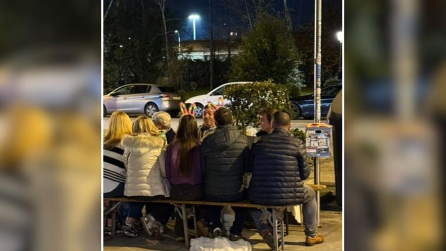 Un grupo de turistas se monta un picnic bajo las luces de la Navidad de Vigo