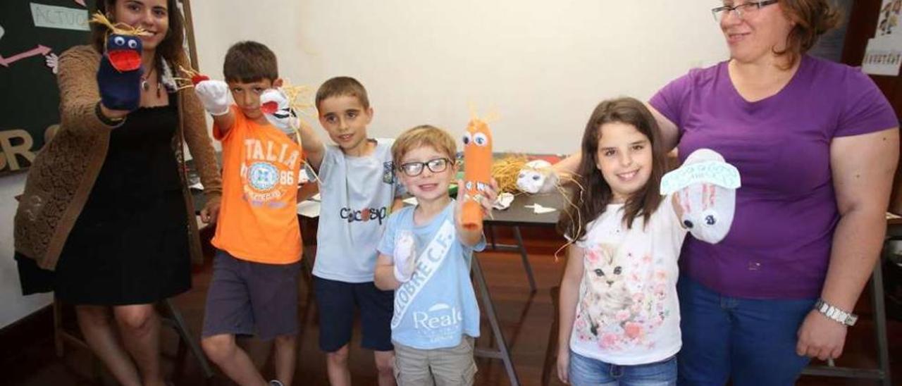 Lara Fuentes junto a los niños participantes en el taller de guiñoles y una de las madres. // Bernabé