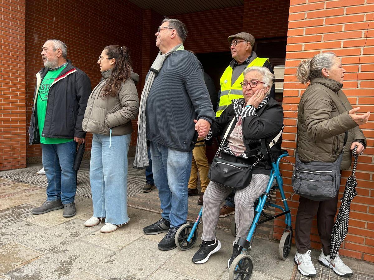 El sacerdote Joaquín Sánchez sujeta la mano a Antonia a las puertas de su domicilio en Alcantarilla