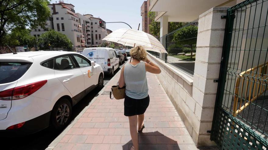 Una mujer pasea por las calles de Murcia con una sombrilla para protegerse del sol.