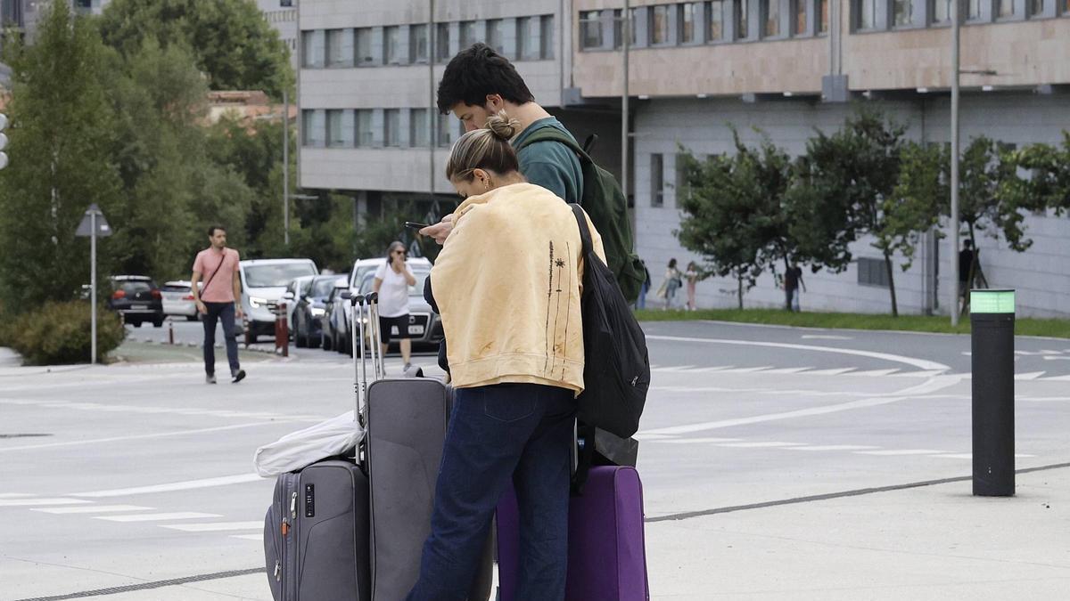 Dos jóvenes con maletas junto a la Estación Intermodal de Santiago