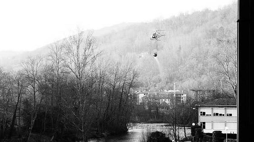 El helicóptero, después de cargar agua en el río Sella, en Cangas de Onís.