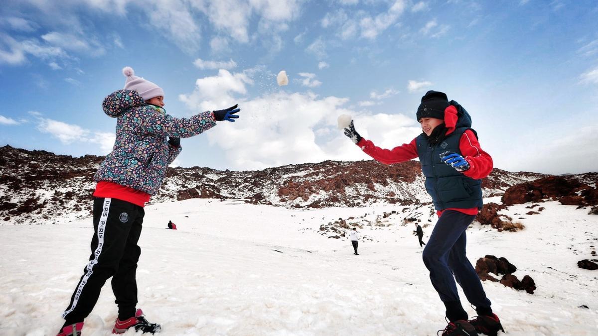 Indira y su primo Pablo juegan a tirarse bolas de nieve.