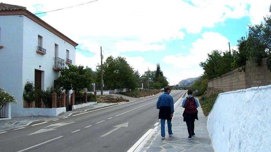 Dos personas caminan por un pueblo de Málaga.