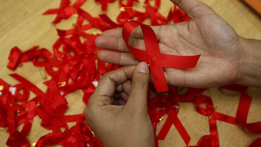 Una mujer con uno de los lazos rojos que simbolizan la prevención del virus del sida.