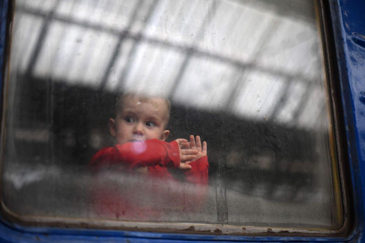 Un niño mira a través de la ventana de un tren que se dispone a partir de la estación de Leópolis, al oeste de Ucrania, en ruta hacia la ciudad de Uzhhorod, cerca de la frontera con Eslovaquia.