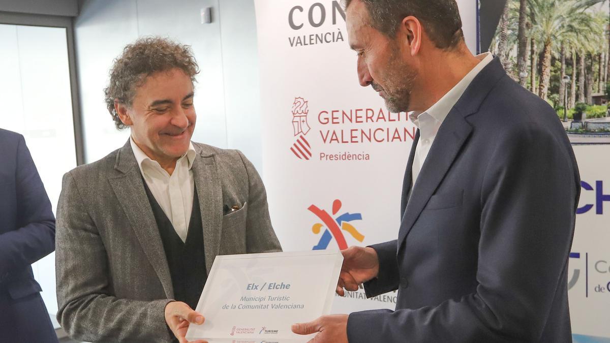 Francesc Colomer entrega a Carlos González la placa que acredita a Elche como municipio turístico.