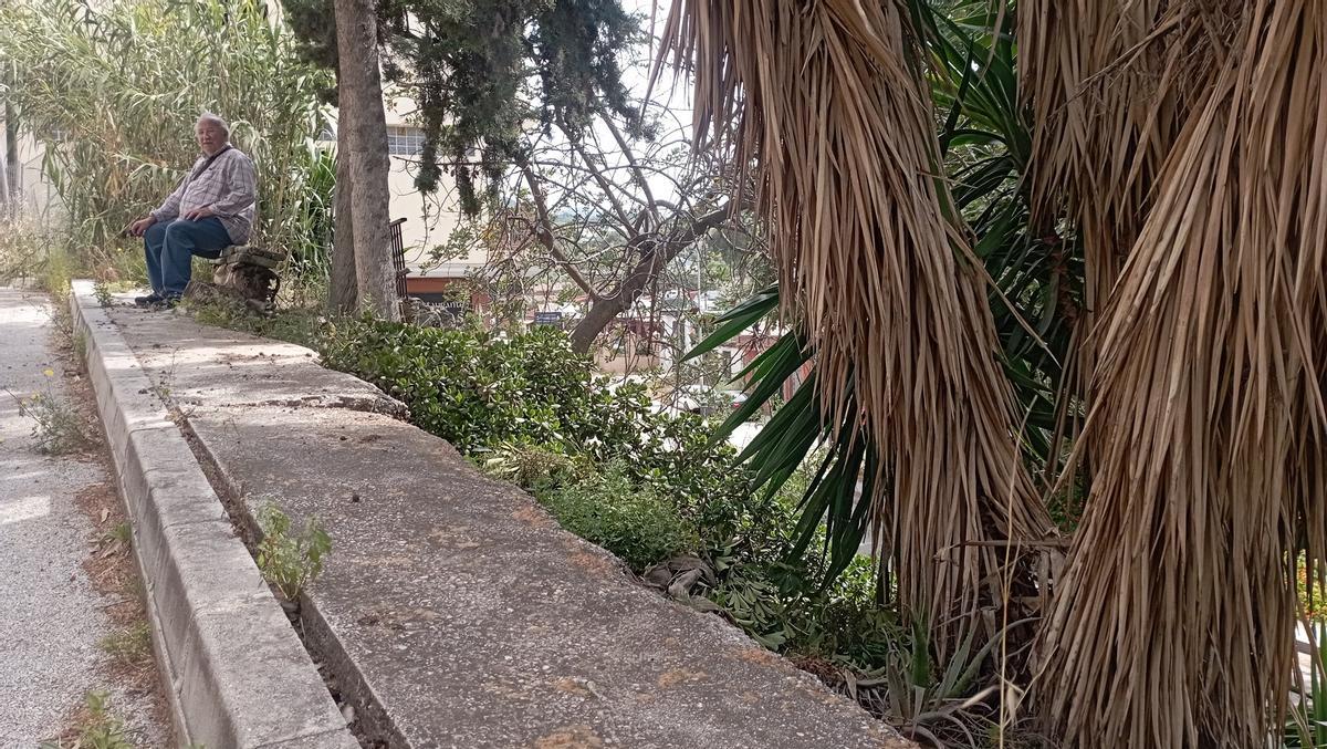 Zona verde descuidada y acera inclinada en calle Obispo Alonso de Santo Tomás, en Monte Dorado