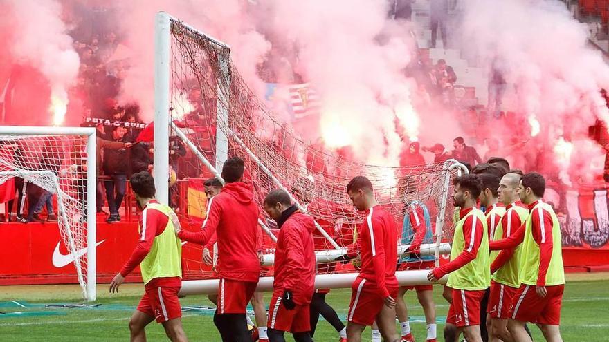 Los jugadores del Sporting trasladan una portería durante el bengaleo de Ultra Boys.