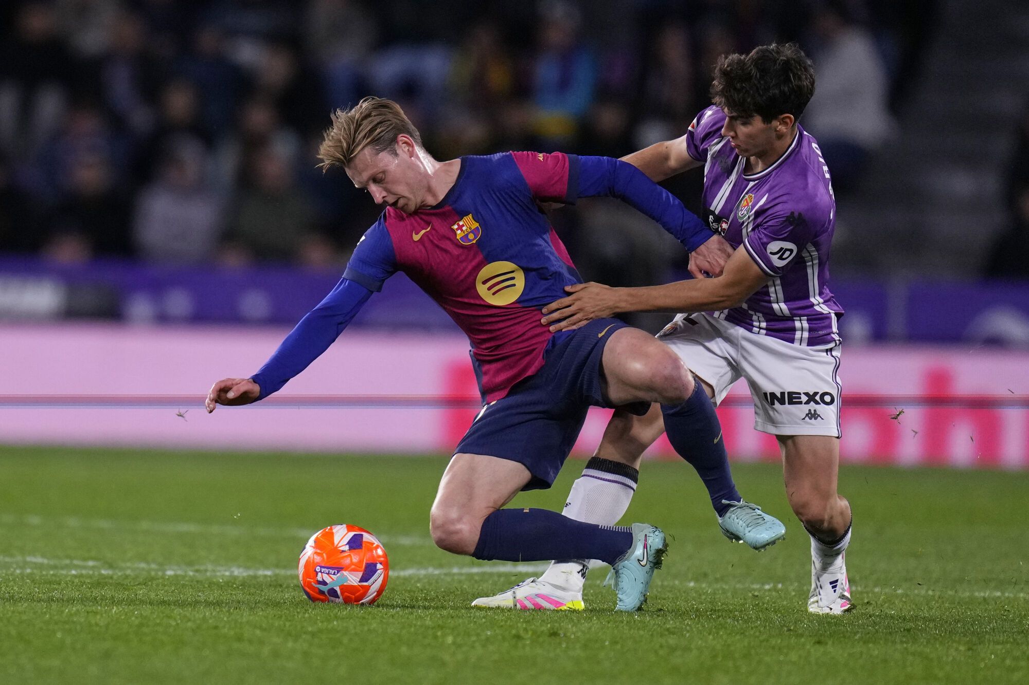 Barcelona's Frenkie de Jong, left, and Valladolid's Mario Martin challenge for the ball during the Spanish La Liga soccer match between Valladolid and FC Barcelona at the Jose Zorrilla stadium in Valladolid, Spain, Saturday, May 3, 2025. (AP Photo/Manu Fernandez)