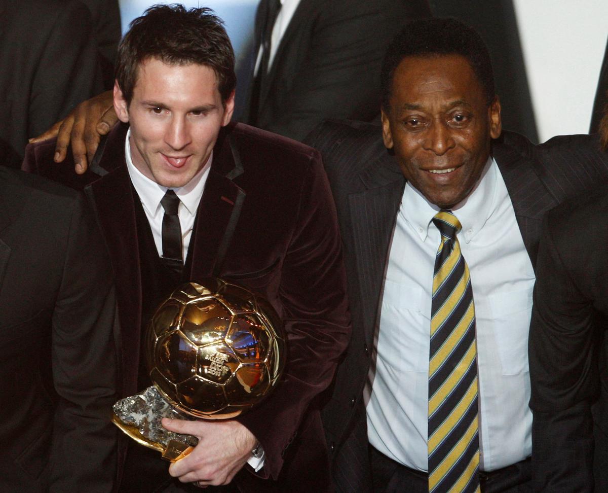 FILE PHOTO: Messi of Argentina, FIFA World Player of the Year holds his FIFA Ballon dOr 2011 trophy next to Pele during the FIFA Ballon dOr 2011 soccer awards ceremony in Zurich