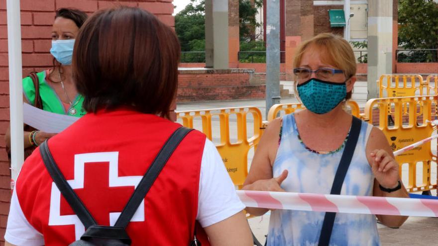 Una voluntària de la Creu Roja atenent una ciutadana que vol fer-se una prova PCR |