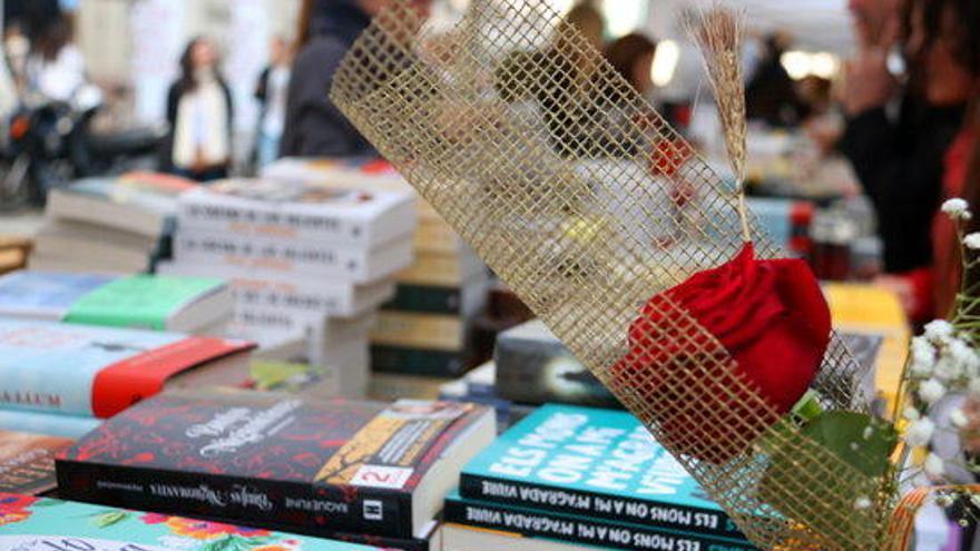 Una parada de llibres de Sant Jordi amb una rosa en primer pla