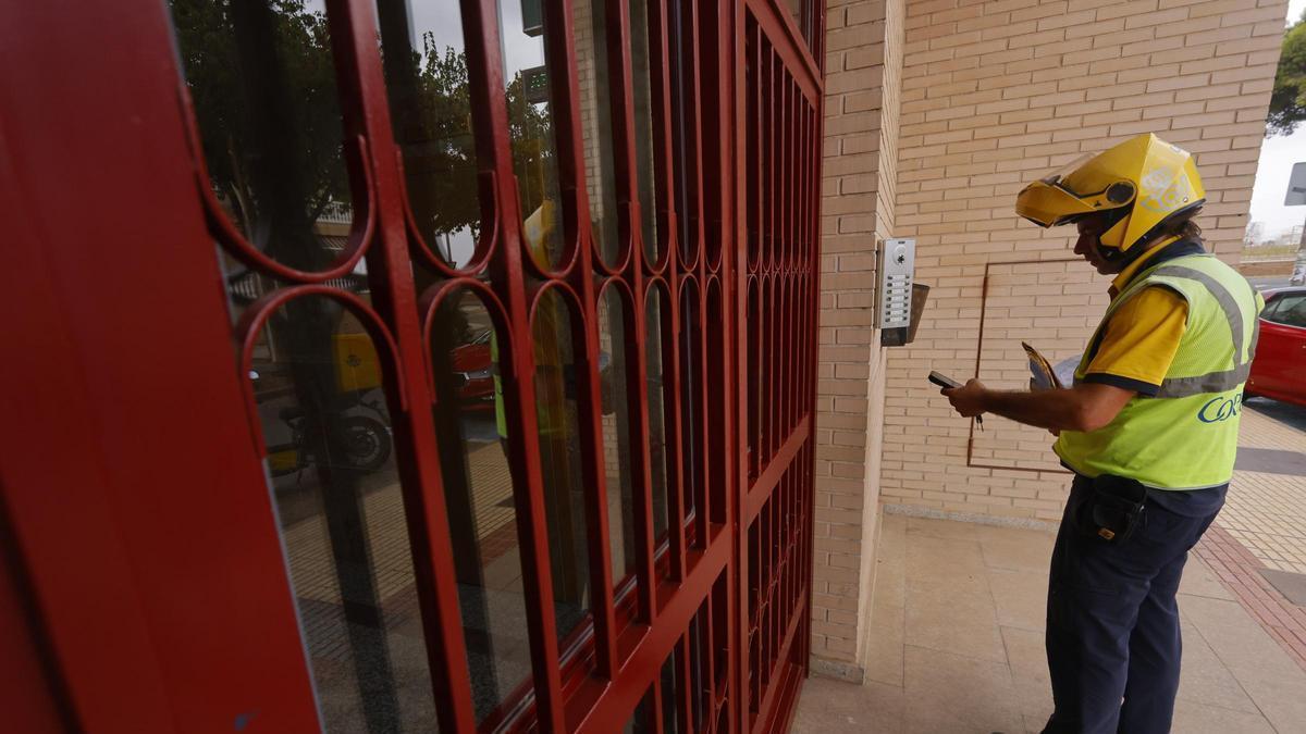 Un cartero de Correos llamando al telefonillo de una vivienda en Los Dolores de Cartagena.