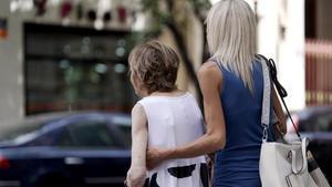 Una mujer mayor, acompañada en una calle de Madrid