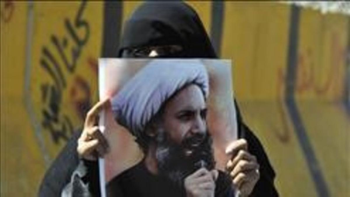 Una mujer sostiene en Yemen la foto del clérigo chií  Al Nimr ajusticiado.