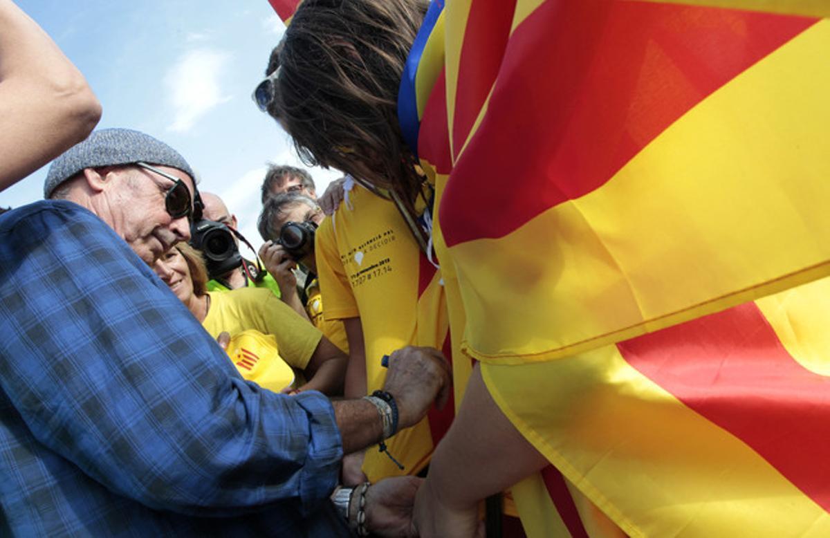 Lluís Llach firma autógrafos en el paso de la Via Catalana por Alcanar.