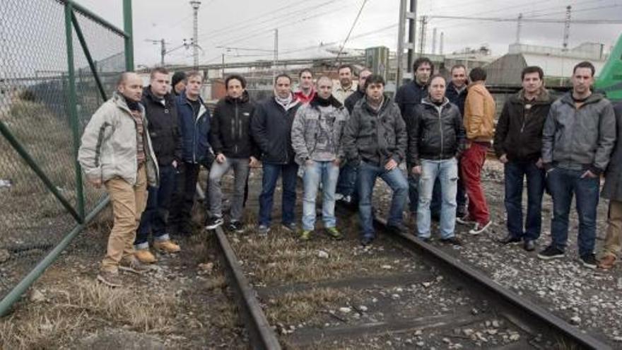 Ex trabajadores de la empresa Ingeniería Montajes del Norte (Imsa), en la playa de vías de San Juan de Nieva. Al fondo, las instalaciones de Asturiana de Zinc.