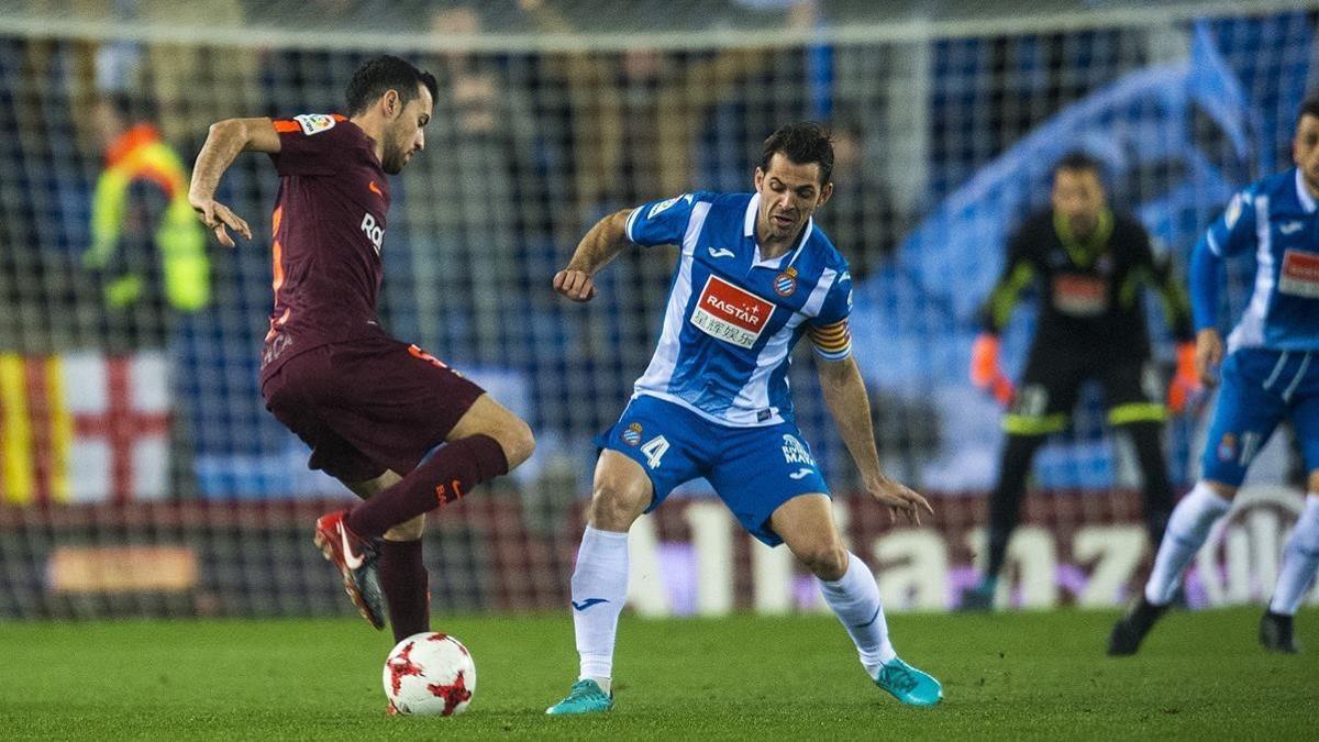 Busquets esconde el balón ante Víctor Sánchez.