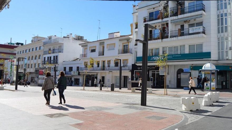 Peatones transitan por la calle Marqués del Duero, cerrada al tráfico por tres bolardos.