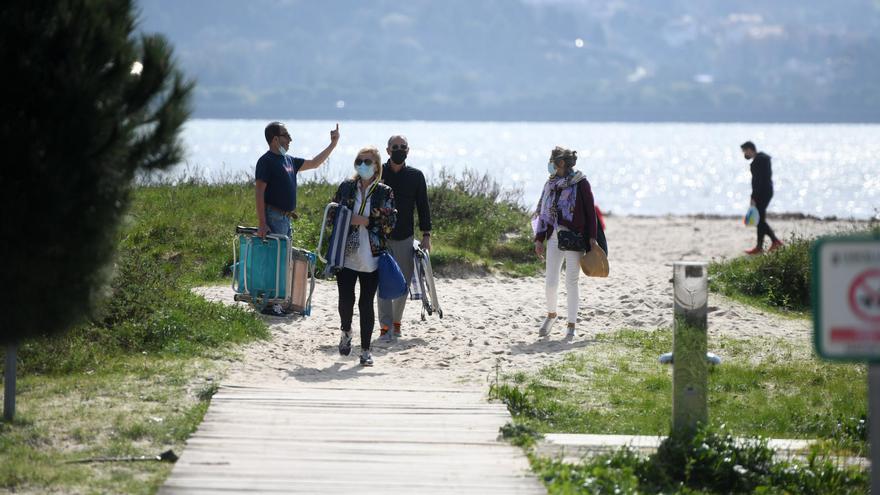 Gente disfrutando de una tarde de buen tiempo en la playa de Lourido, en Poio.