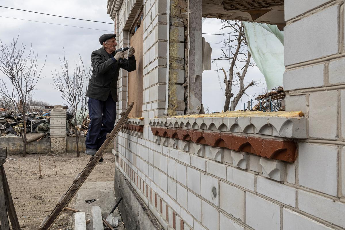 Un hombre arregla su casa destruida, en la aldea de Krasylivka en las afueras de Kiev.