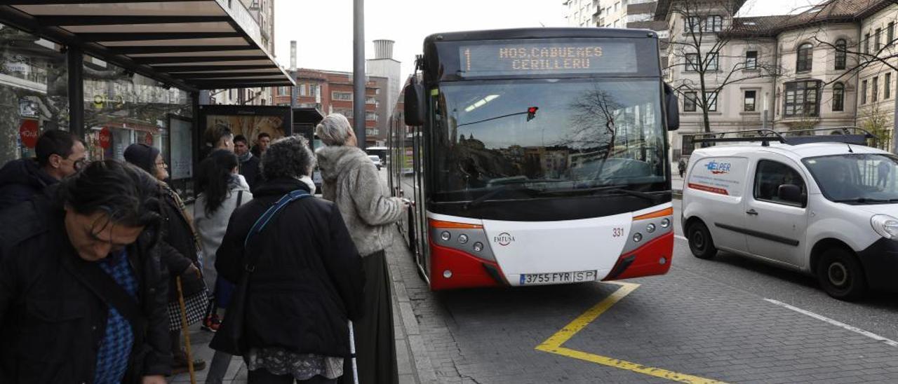 Varios usuarios aguardan la llegada del autobús a la parada