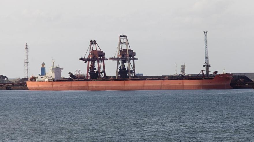 Un barco descargando en Ebhisa, con los dos pórticos y la grúa automóvil que operan en la terminal de graneles sólidos de El Musel.