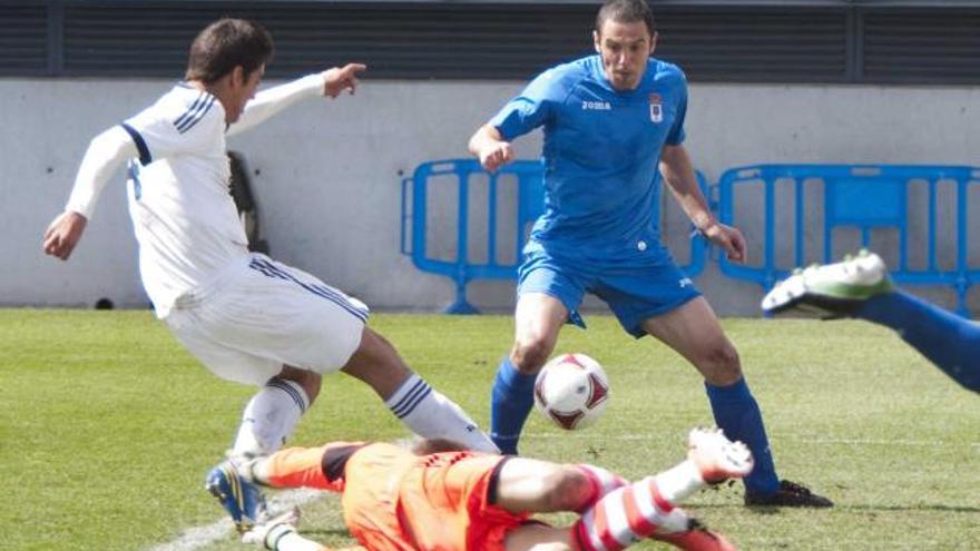 Un defensa del Madrid despeja ante Diego Cervero, con el portero Rubén en el suelo. | lof