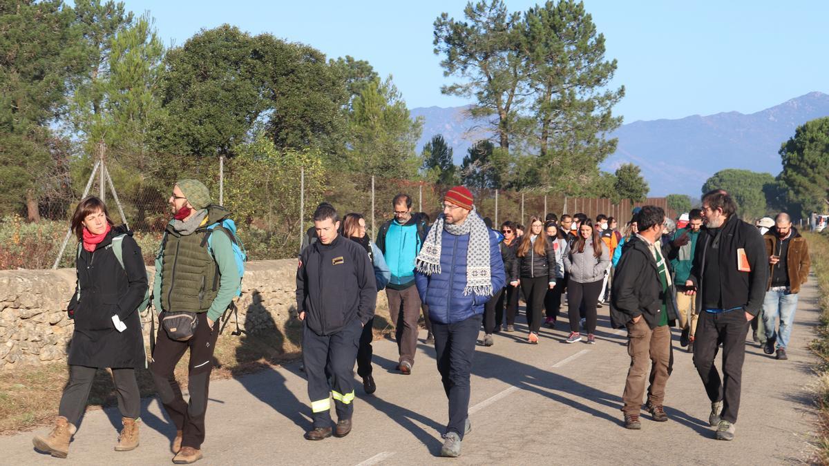 Un grup de persones caminant per la carretera de Cantallops en una visita per conèixer alguns dels projectes d'energies renovables a Girona