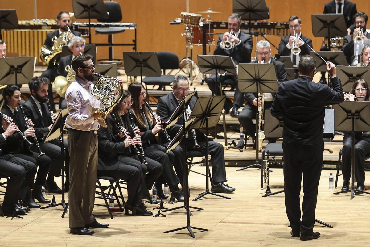 Simon Lewis, de pie, tocando la trompa junto a la banda de música «Ciudad de Ovido», ayer, en el Auditorio.