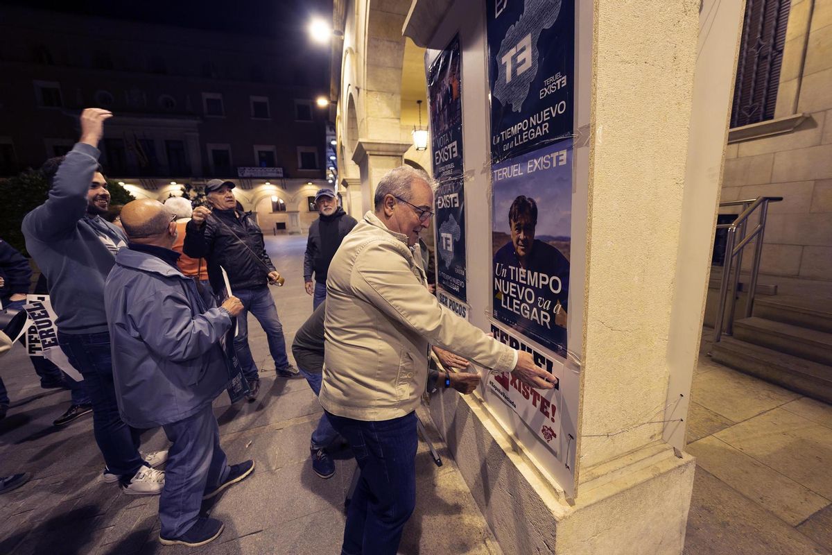 El candidato de Teruel Existe a la alcaldía del ayuntamiento de Teruel, Enrique Marín, en la tradicional pegada de carteles hoy jueves noche en la Plaza San Juan de Teruel al inicio de la campaña electoral para las elecciones del 28-M.