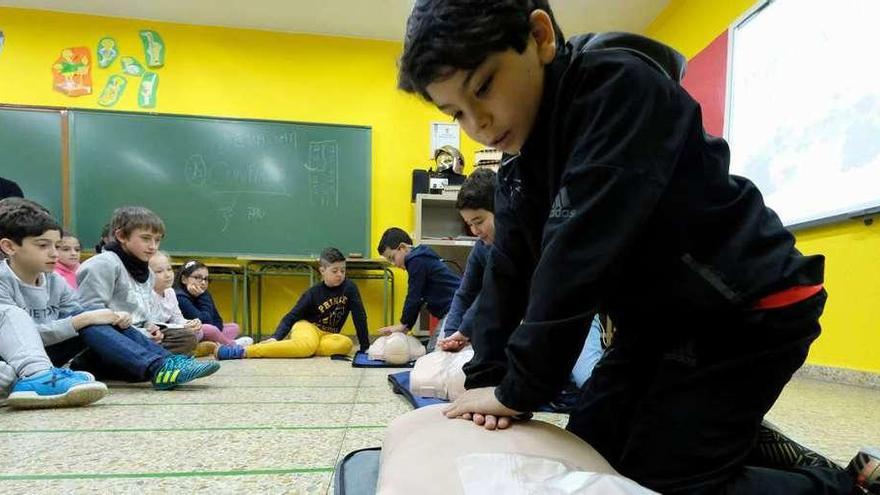 En primer término, Adrián Dosantos, practicando la RCP con un maniquí.