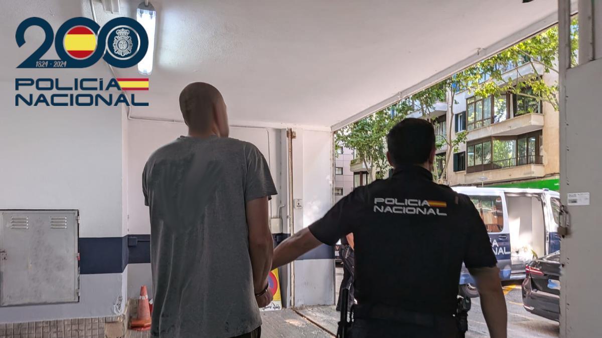 Un agente de la Policía Nacional conduce detenido al fugitivo eslovaco.