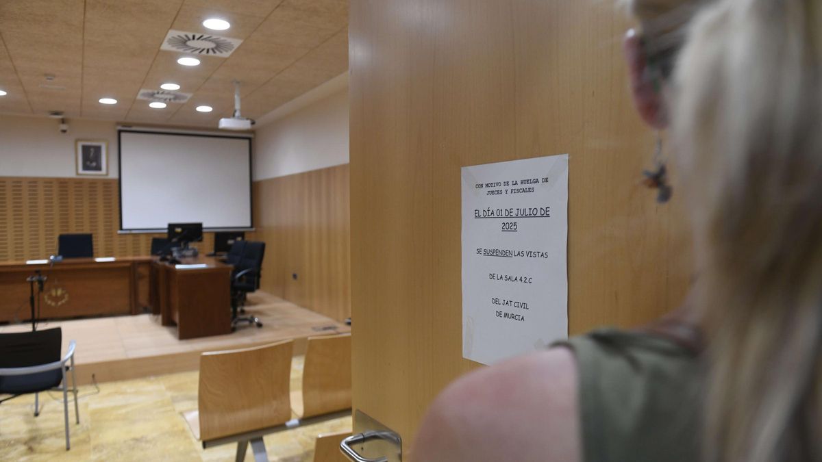 Sala de vistas vacía y cartel anunciador de la huelga, este martes en la Ciudad de la Justicia de Murcia.