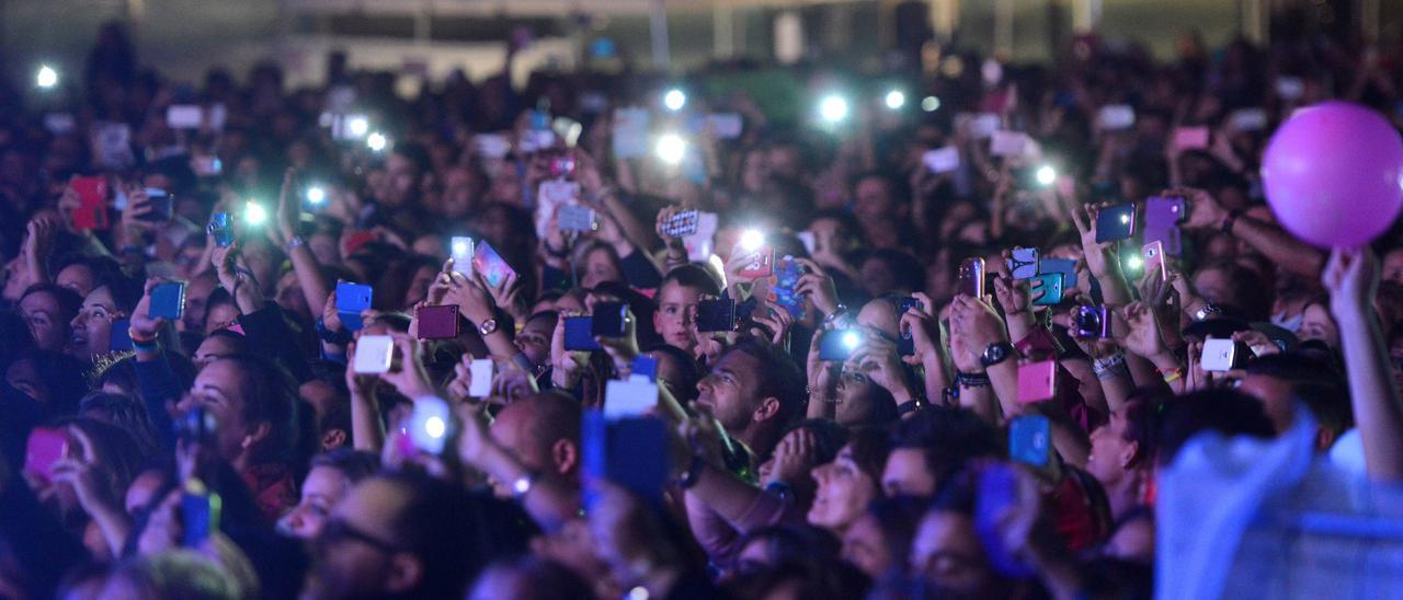 Asistentes a un concierto en Pontevedra hacen fotos y graban vídeos con sus teléfonos móviles.