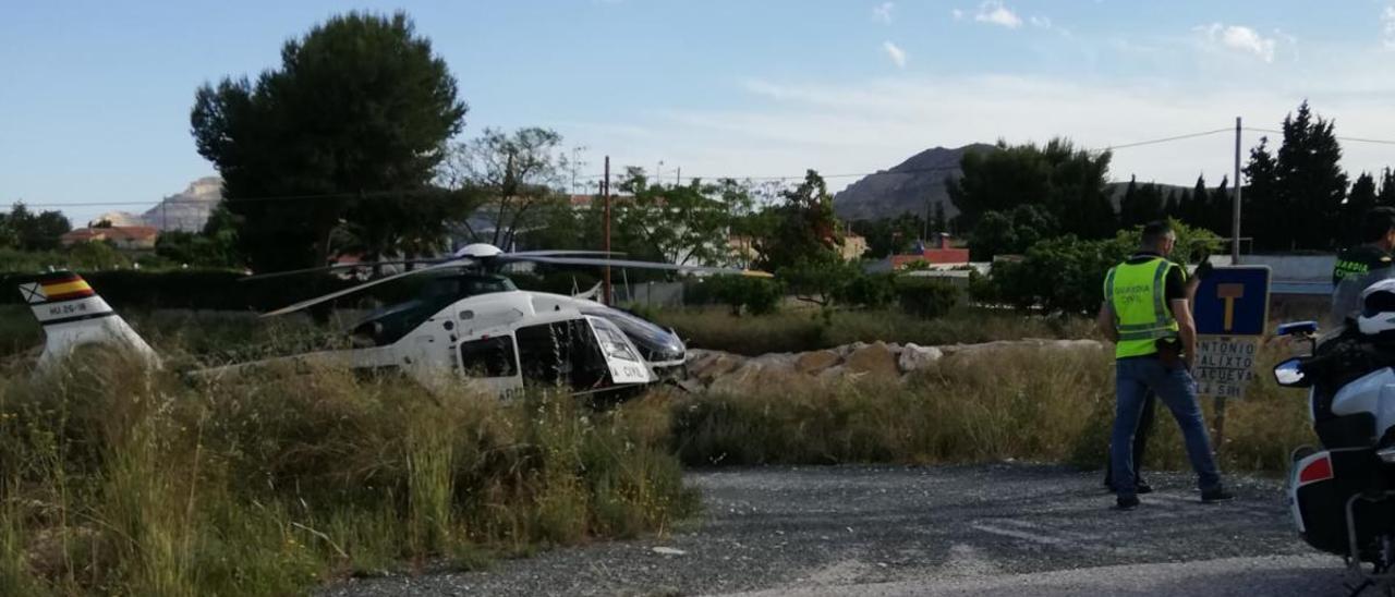 El helicóptero y un agente de la Guardia Civil en el lugar de las detenciones.