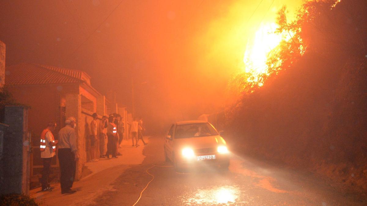 Un incendio cerca las casas en Arousa. 