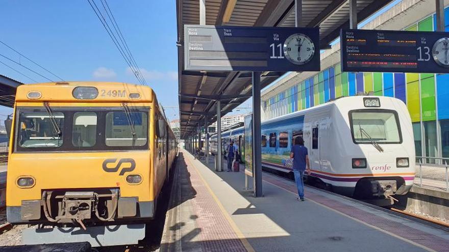 Dos automotores de Comboios de Portugal y Renfe en la estación de Guixar.