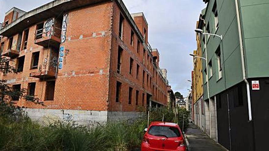 Edificio inacabado de las calles Luis Peña Novo y Mozart, con pintadas en su fachada.