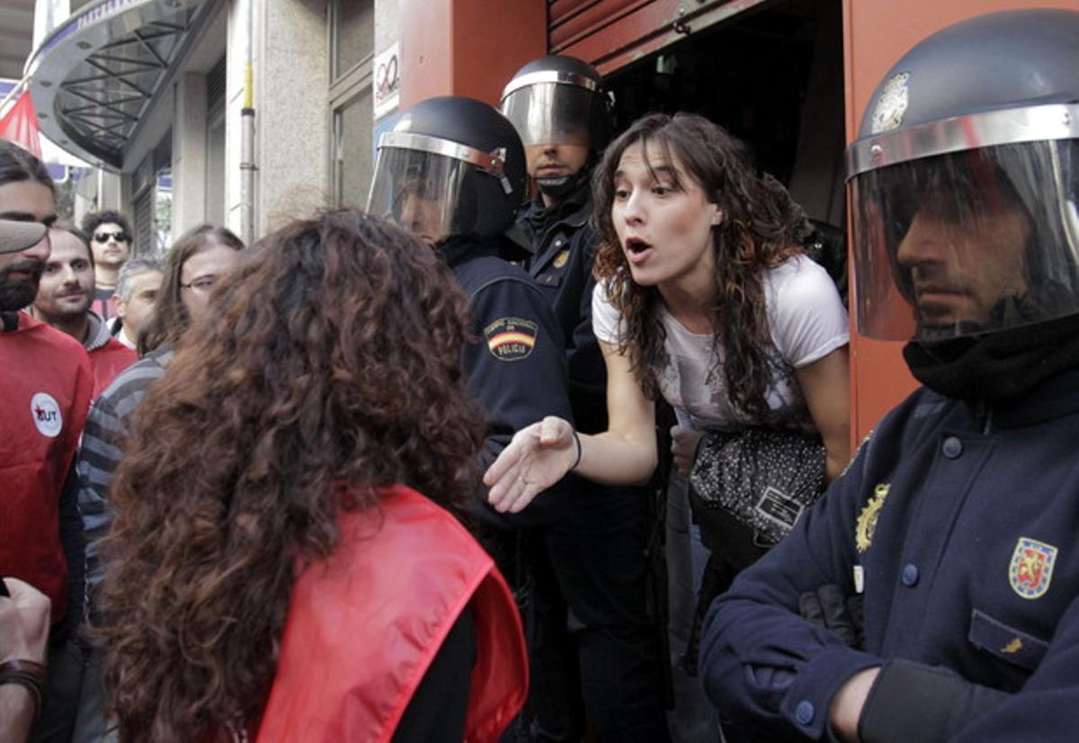 L’empleada d’un local es nega a tancar davant la pressió d’un piquet i protegida per la Policia a Santiago de Compostel·la.