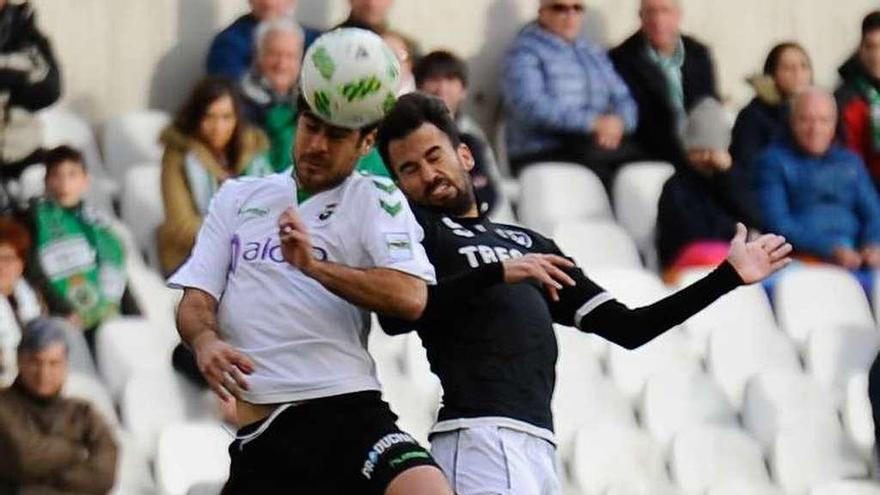 Omar disputa un balón de cabeza con un jugador del Racing.