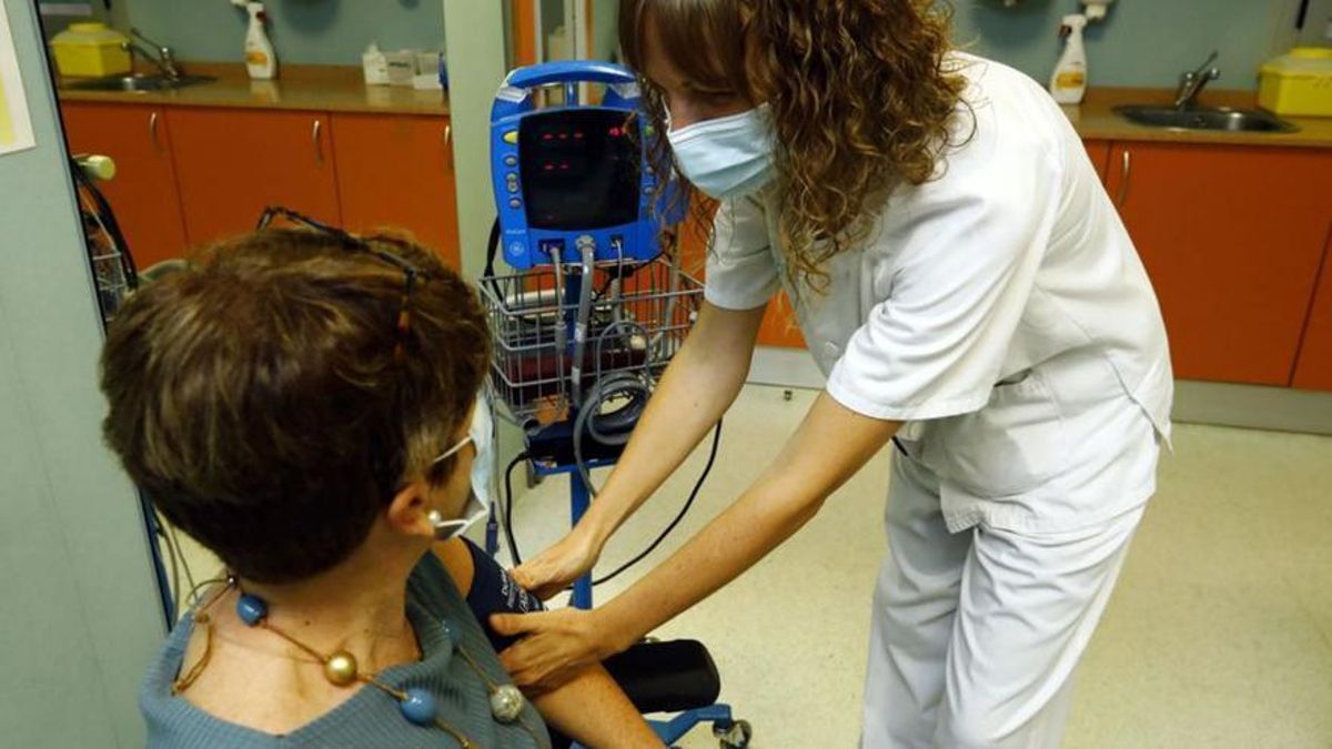 Una enfermera toma la tensión a una paciente en la consulta del centro de salud.