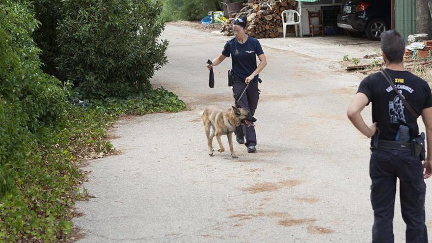 Dos policías registran la finca en busca de pruebas.