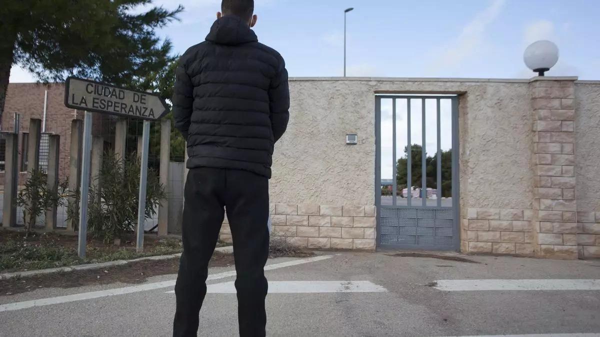 Un menor migrante en la puerta de un centro, en una imagen de archivo.