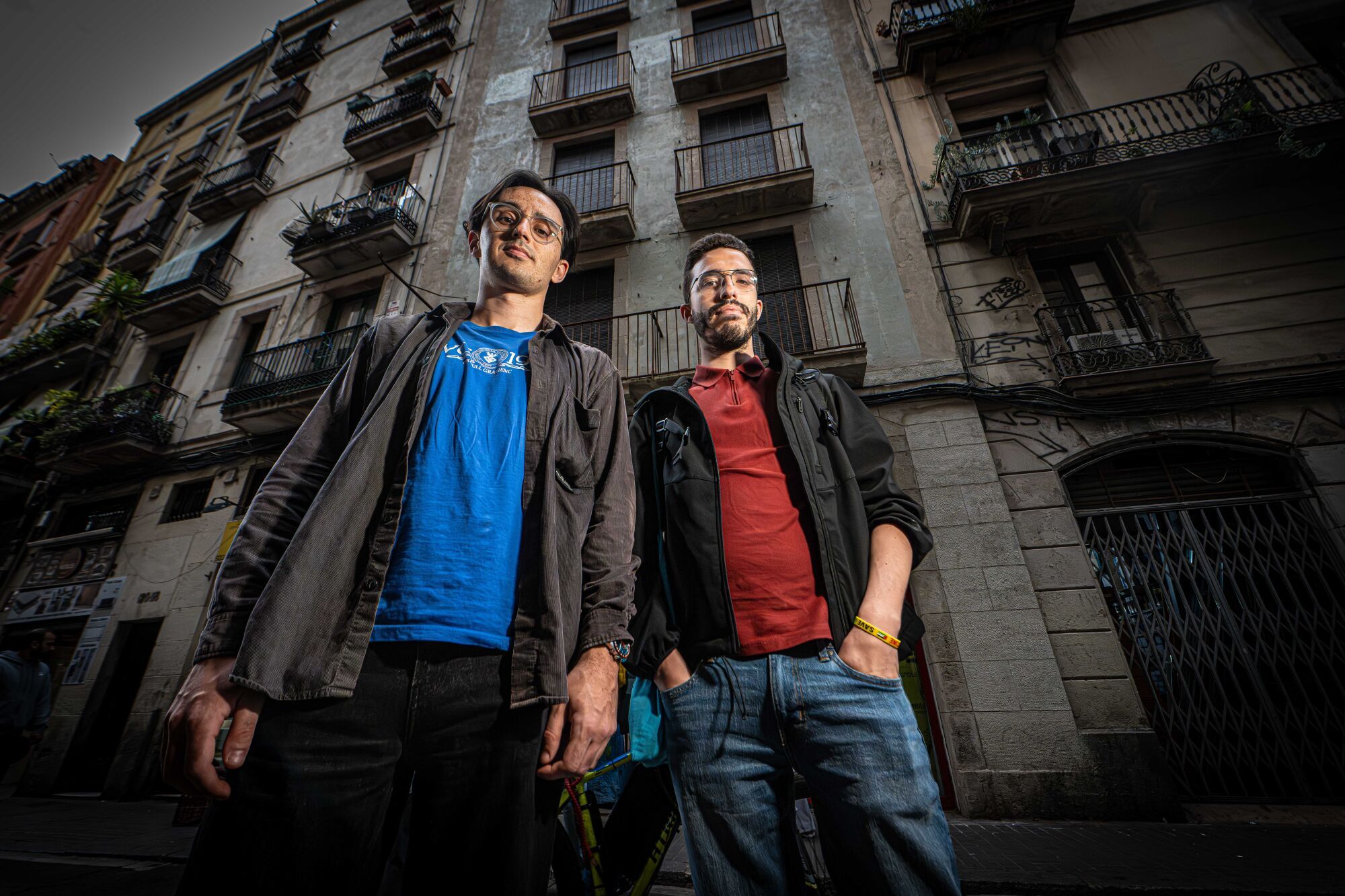 Òskar y Juanma, delante de la finca del número 116 de la calle Hospital, en Barcelona, en la que han obtenido un piso público y que permanece vacía.
